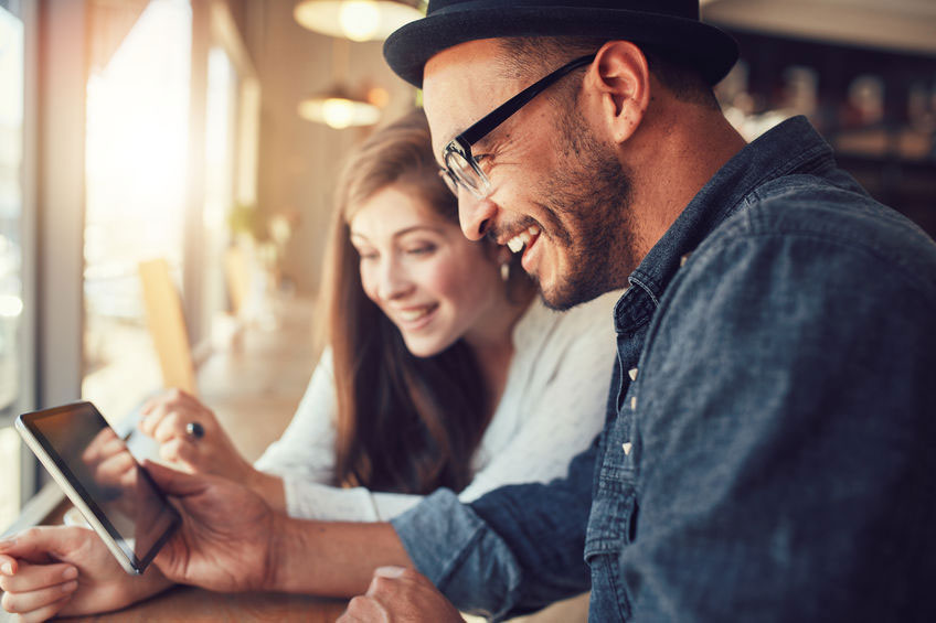 happy man and woman looking at a tablet